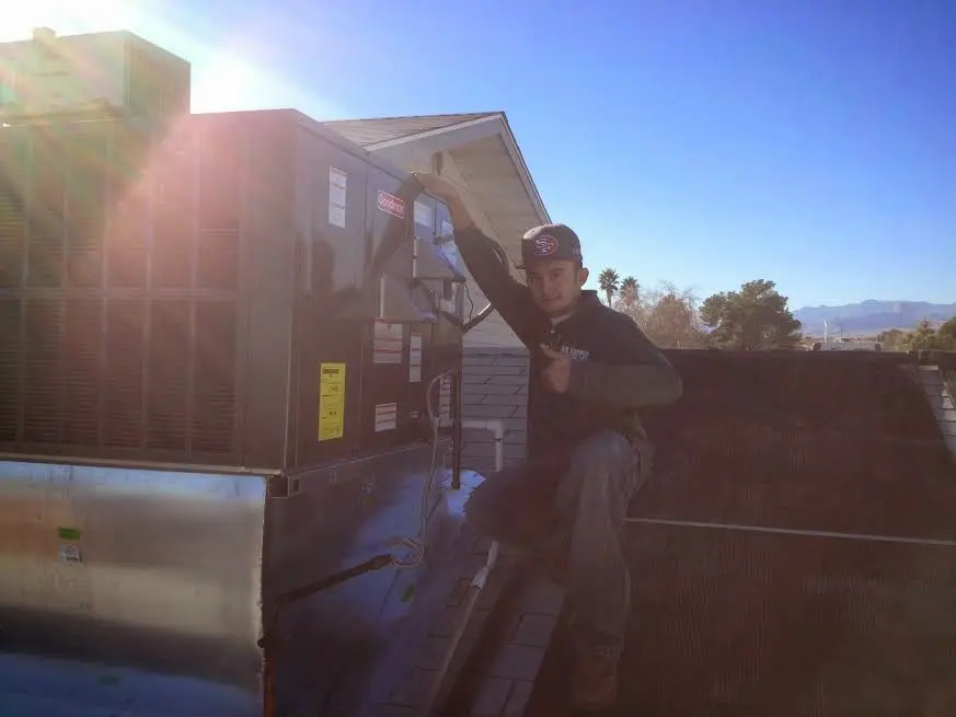 HVAC technician performing Boiler Repair on a rooftop unit in Stowe
